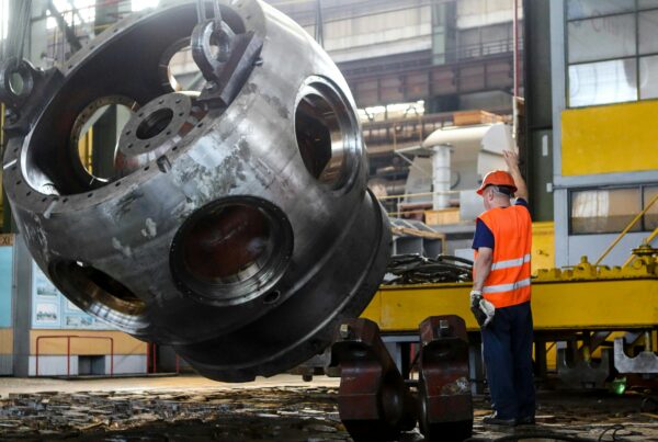 Industrial rigger guiding heavy equipment lift in manufacturing facility — RigX rigging and millwright services Atlanta