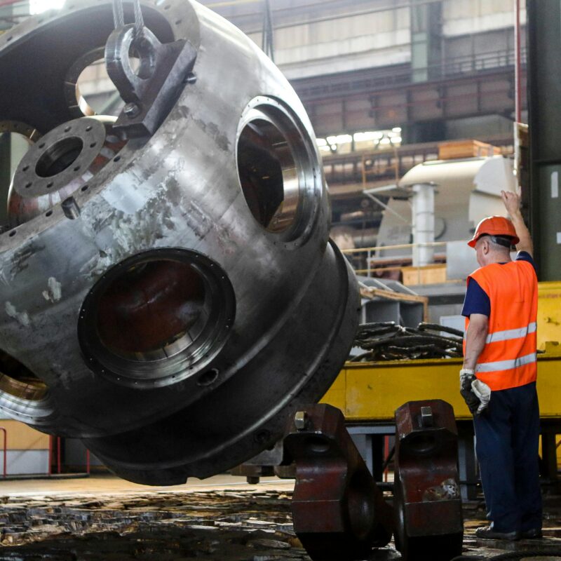 Industrial rigger guiding heavy equipment lift in manufacturing facility — RigX rigging and millwright services Atlanta