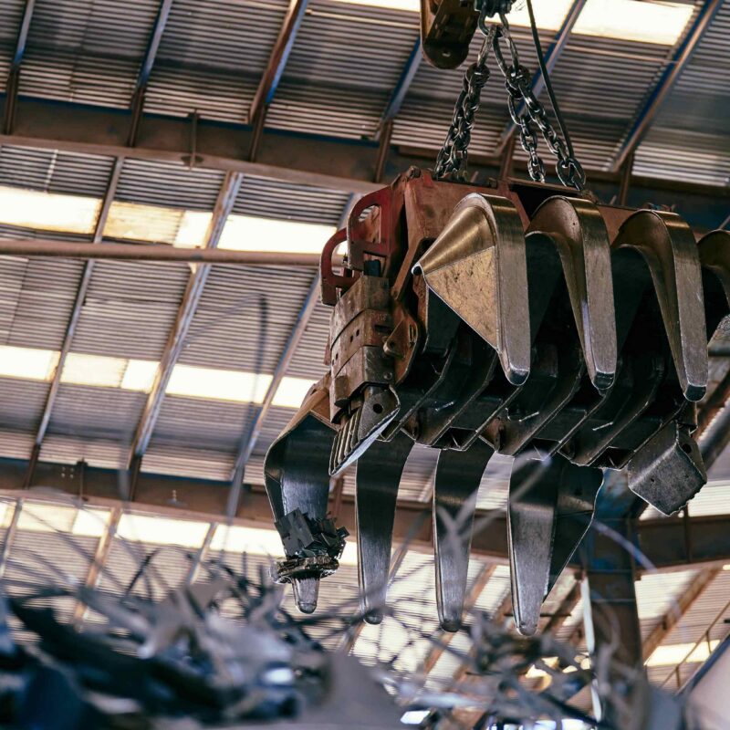 Industrial crane hook and chain suspended inside manufacturing facility for heavy equipment rigging in Atlanta